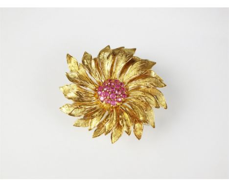 A ruby set sunflower brooch, designed as a central pave set cluster of round cut rubies mounted within graduated wrythen yell