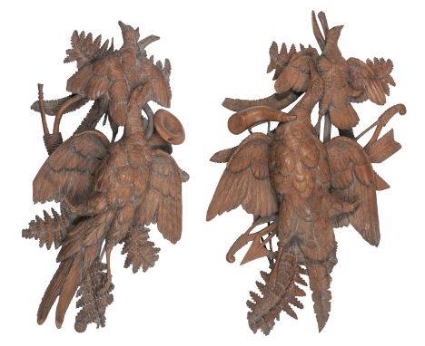 A PAIR OF BLACK FOREST CARVED WALNUT HUNTING TROPHIES OF DEAD GAMEBIRDSDecorated against hunting horn and bow and arrow, larg