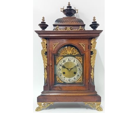 A late 19th century German mantle clock, maker J Unghans, of architectural form with an urn finial above a carved 'tiled' roo