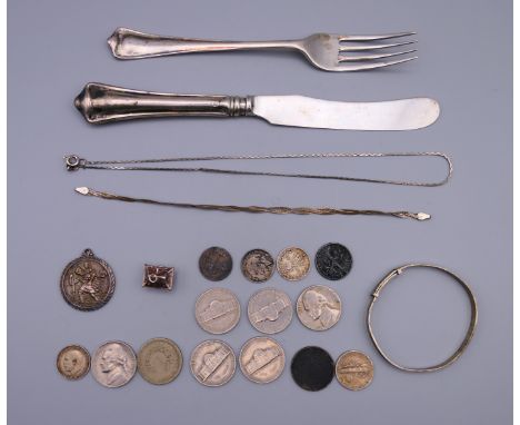 A quantity of various silver, including coins, knife and fork, St Christopher pendant, etc. Knife 18 cm long.