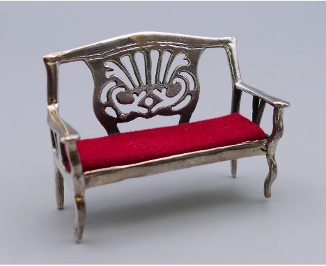 A silver pin cushion formed as a bench. 4.5 cm long, 3.5 cm high.