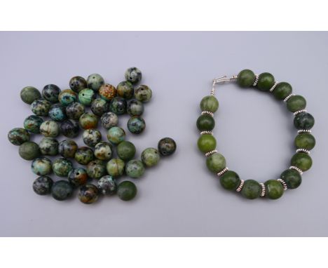 A jade and silver bracelet and a quantity of loose jade beads.  Bracelet 19 cm long. 