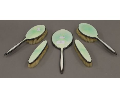 A silver and enamel dressing table set.