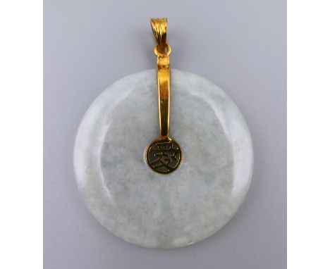 A 14 K gold mounted jade disc pendant.   3.5 cm diameter.