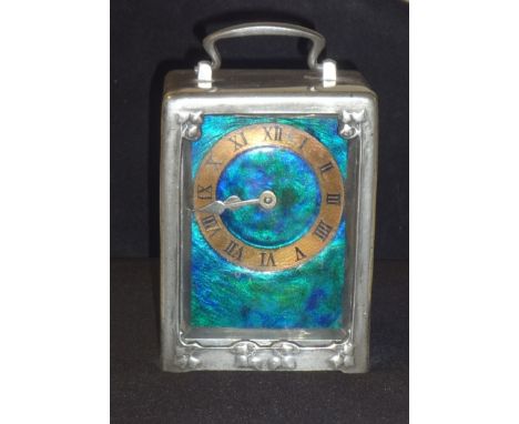 A pewter and enamel carriage clock the design attributed to Archibald Knox, cast with tendrils, with blue and green enamel di