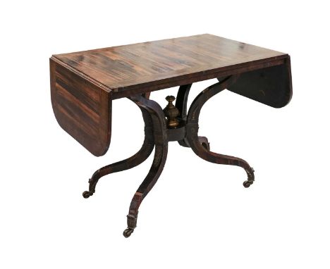 In the manner of George Oakley; A Regency Coromandel sofa table the top and two flaps with brass inlaid rosewood banding and 