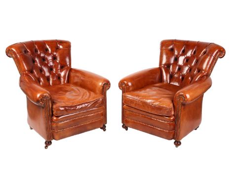A pair of craftsman-made Regency-style cognac hide armchairs, 20th century, with buttoned scroll backs with close nailed deta