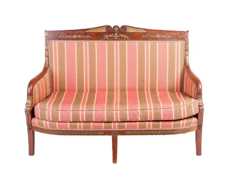 A French Empire flame-grained bowfronted mahogany salon sofa with architectural scroll cresting above stuff over striped silk