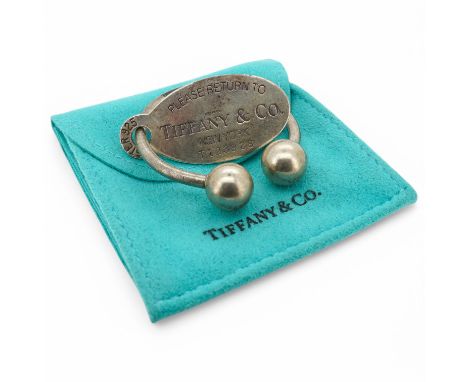 Tiffany &amp; Co, a silver scarf ring, of torque design with a hanging tag, signed Tiffany &amp; Co., British hallmarks, spon