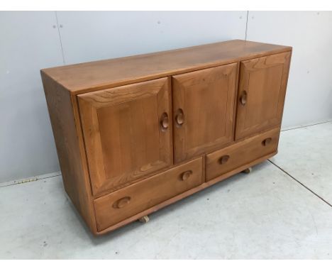 An Ercol Windsor elm dining suite comprising a sideboard, six ladderback dining chairs and extending dining table. Condition 
