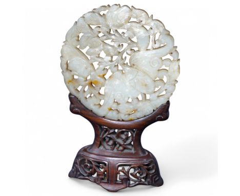 A Chinese pierced jade disc, on stand, 15cm high. Condition - good