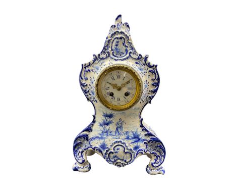 French Faience porcelain mantle clock with blue and white decoration c1890, in a rococo style case with scrollwork and floral