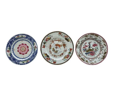 Three 18th century Chinese porcelain Famille Rose plates, the first painted with a central pair of Buddhist lion dogs playing