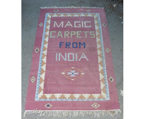 Red ground carpet reading 'Magic Carpet from India'.   