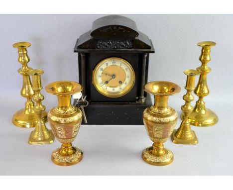 A polished slate mantel clock, a pair of Indian brass vases and two pairs of brass candlesticks.   