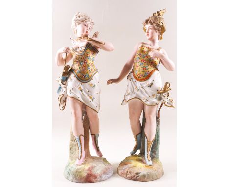 A pair of German porcelain bisque figures of ladies, one with wings, the other helmet and sword, 32.5cm high