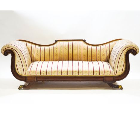 A Regency/Empire mahogany recamier style sofa with scroll end terminals and shaped back over a plain apron on splayed legs wi