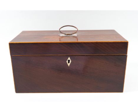 A Regency mahogany tea caddy with boxwood string inlay, with silver plated ring handle, opening to reveal two covers with rib