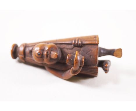 A Japanese carved wood figure of a netsuke in the form of a man holding a bowl, 6.5cm high