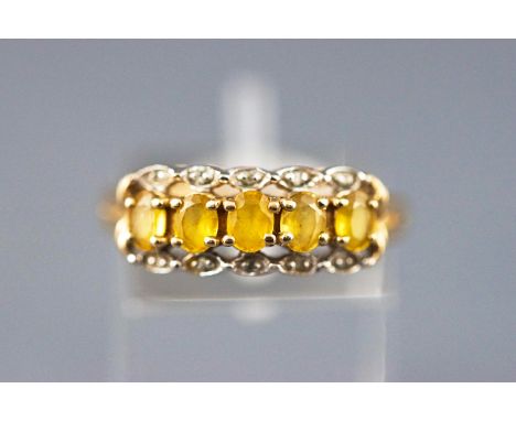 A yellow metal dress ring set with five yellow beryl and diamonds. Hallmarked 9ct gold, Sheffield. NB: Stones tested to the e