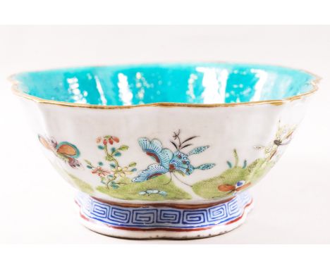 A Canton enamel bowl, painted with butterflies in a landscape, with Daoguang mark, 19cm diameter