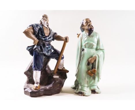 Two Chinese Shiwan (mud man) figures, one standing on a rocky base with an axe, 24.5cm high and smaller