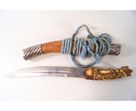 A Balinese knife with carved bone handle, and white metal mounted scabbard, 36cm long