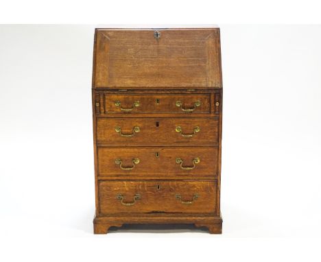 A Georgian oak bureau with fall front over lopers and four drawers with brass swan neck handles on a bracket footed base, the