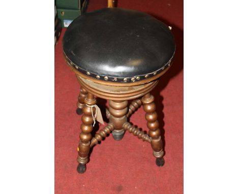 A walnut bobbin turned and black leather studded topped circular work stool, with rise-and-fall action