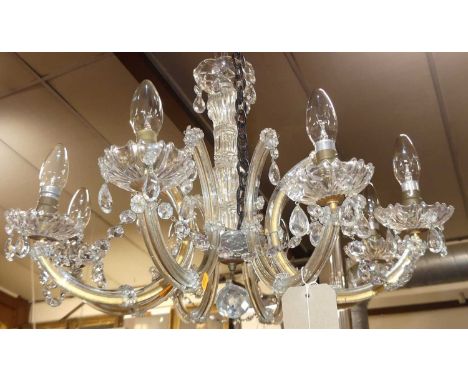 An early 20th century cut crystal glass eight light chandelier, having C-scroll branch arms, approx drop 55cm