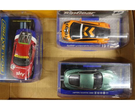 Three various plastic cased Scalextric slot racing cars to include an Aston Martin DBS