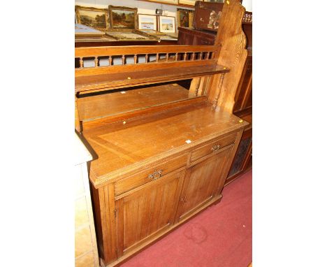 A late Victorian oak chiffonier, the raised superstructure with mirror inset back, over twin frieze drawers to conforming pan