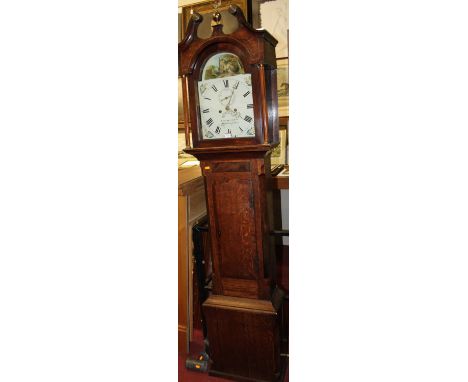 An early 19th century provincial oak and mahogany crossbanded longcase clock, having a painted arched dial, twin winding hole