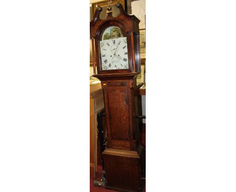 An early 19th century provincial oak and mahogany crossbanded longcase clock, having a painted arched dial, twin winding hole