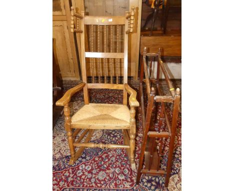 An early 20th century beech bobbin turned rush seat open rocking elbow chair, together with an Edwardian towel rail (2)