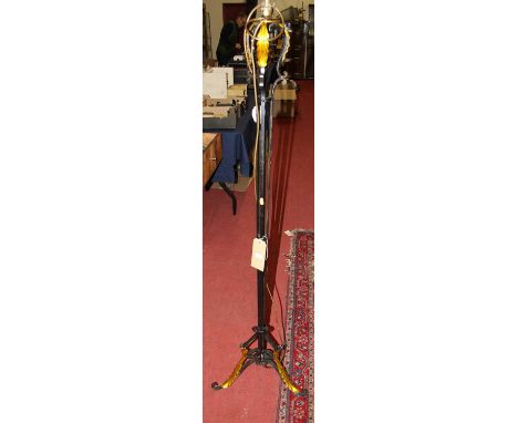An early 20th century black pained and floral scroll decorated wrought iron standard lamp