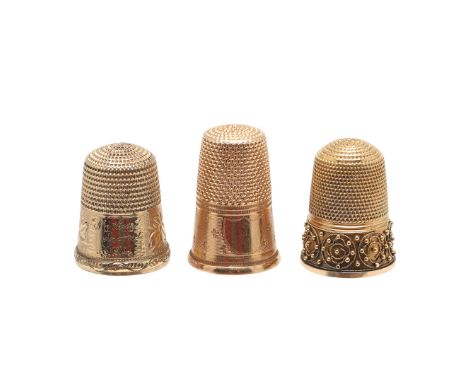 THREE GOLD THIMBLES. one with engine-turned decoration, one with applied filigree, both unmarked and an engraved example with