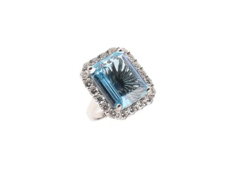 AN AQUAMARINE AND DIAMOND CLUSTER RING. the step-cut aquamarine weighs approximately 12 carats and is set within a surround o