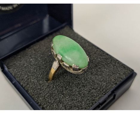 AN 18CT GOLD AND JADE SET DRESS RING, the single jade cabouchon in a white metal pierced setting, ring size P, 6.3 grams. 