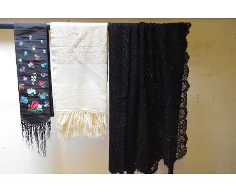 A black silk scarf embroidered with floral sprays, a cream wool evening stole, a machined lace mantilla, two pairs of Chinese