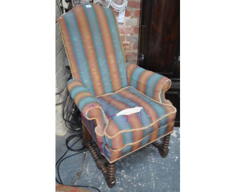 An 18th century style upholstered high back armchair over a bobbin turned under frame, the back leg stamped 8660