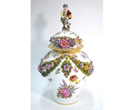 A Dresden oviform vase and domed cover with boy and dog finial; decorated with garlands of flowers in high relief on both vas