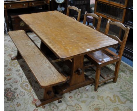 A Yorkshire golden oak cottage dining table by Kingpost, the rectangular adzed top raised on substantial trestle ends united 