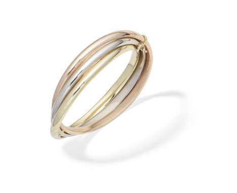 TRI-COLOURED BANGLE, 1995Designed as three rigid interlocking hoops, mounted in 9 carat gold, UK import mark, inner circumfer