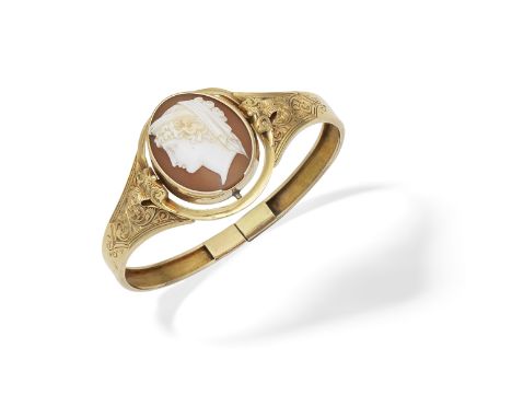 SHELL CAMEO BANGLE,  CIRCA 1860The shell cameo carved to depict an idealised Roman goddess in profile, facing left, between s