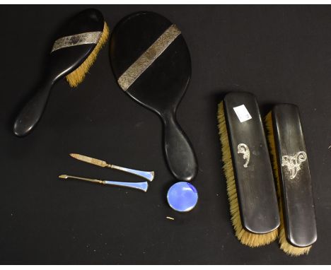 A silver mounted ebony dressing table set; a silver and enamel pill box, Birmingham 1928; silver and enamel hafted manicure t