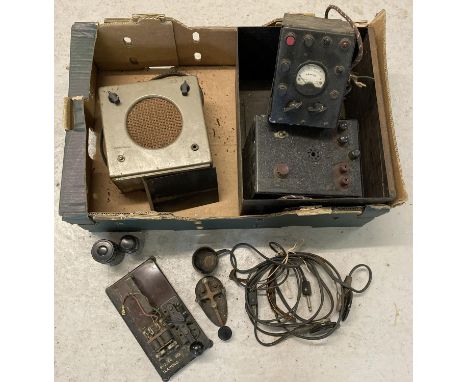 A box containing a collection of vintage Morse code equipment. To include a YA 2488 WWII ear Buzzer Sig training unit, a pair