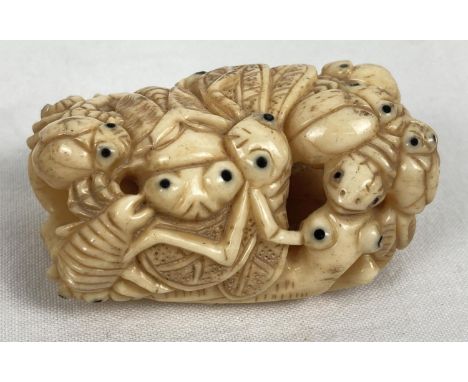 A carved bone netsuke in the form of a ring of crickets, beetles and bugs. Signature mark to reverse. Approx. 5cm long. 