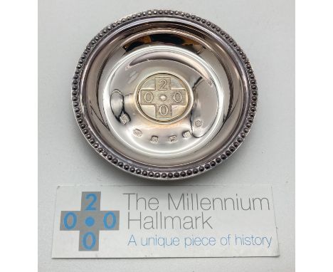 A boxed Millennium silver circular shaped pin dish with beaded detail to rim. With large Millennium mark and full hallmarks t