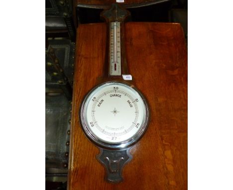 An oak aneroid barometer with thermometer